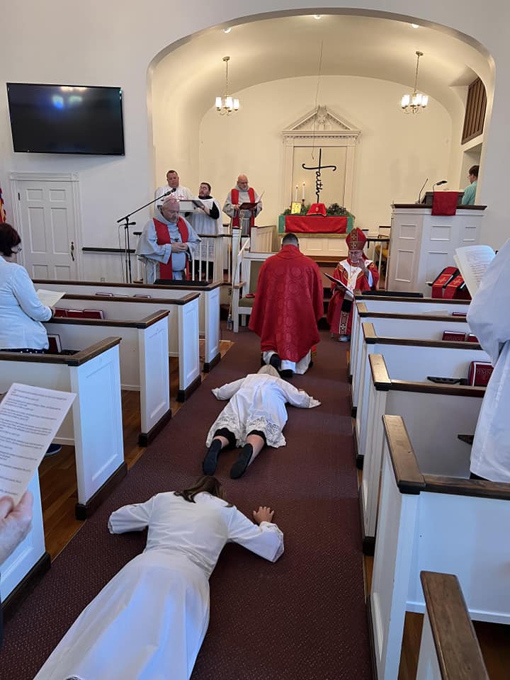Ordinands prostrate before the altar during ordination liturgy